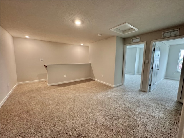 unfurnished room with light carpet and a textured ceiling