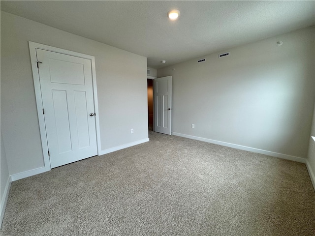 unfurnished bedroom with carpet floors and a textured ceiling