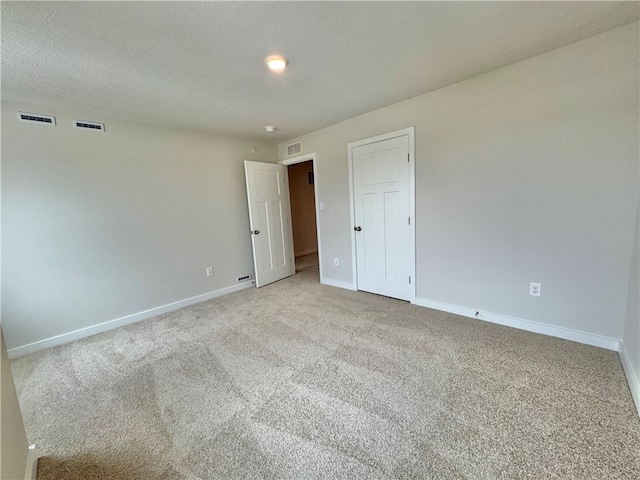 carpeted spare room with a textured ceiling