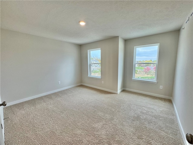 carpeted spare room featuring a textured ceiling