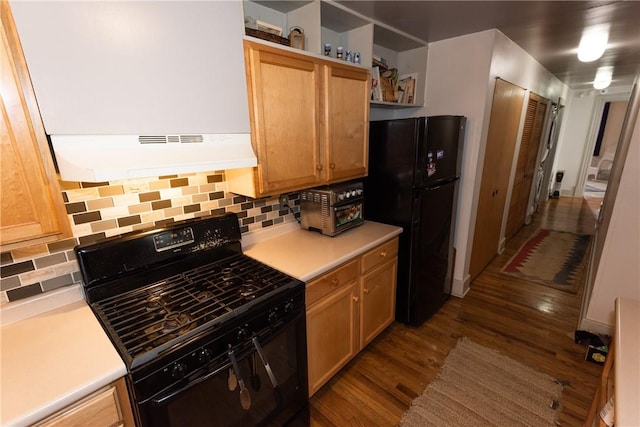 kitchen with wood-type flooring, tasteful backsplash, and black appliances