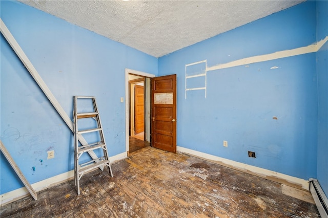 unfurnished bedroom featuring a textured ceiling, dark wood-type flooring, and a baseboard heating unit