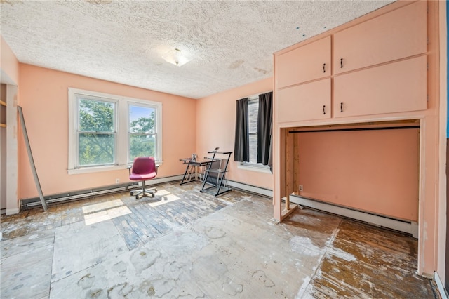 interior space featuring a textured ceiling and a baseboard heating unit