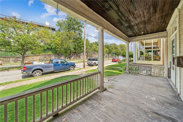 wooden terrace featuring a yard and a porch