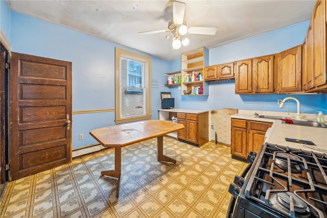 kitchen featuring ceiling fan, sink, black gas stove, and a baseboard heating unit