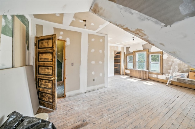 bonus room with radiator heating unit, light hardwood / wood-style floors, and vaulted ceiling