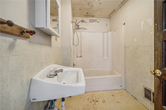 bathroom featuring shower / bathtub combination and tile walls