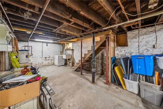 basement featuring washer / clothes dryer, electric water heater, and sink