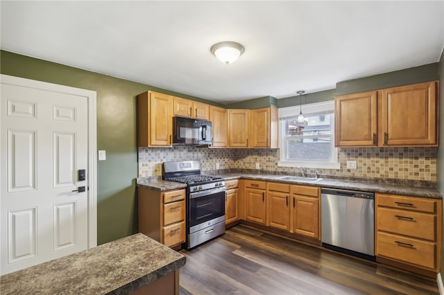 kitchen with backsplash, stainless steel appliances, dark wood-type flooring, sink, and decorative light fixtures