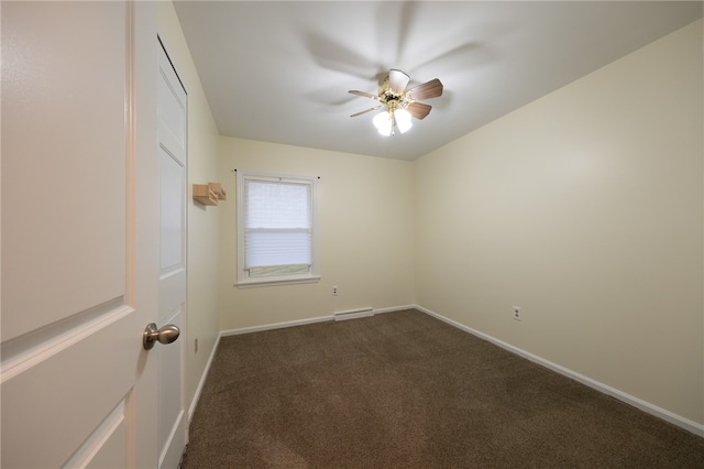 empty room featuring ceiling fan, dark carpet, and a baseboard heating unit