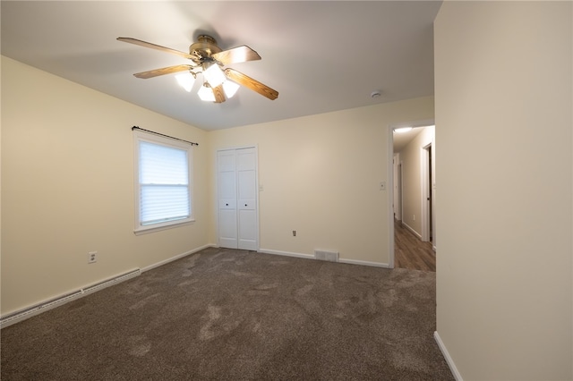 spare room with ceiling fan, dark carpet, and a baseboard radiator