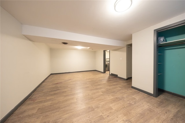 basement with light hardwood / wood-style flooring