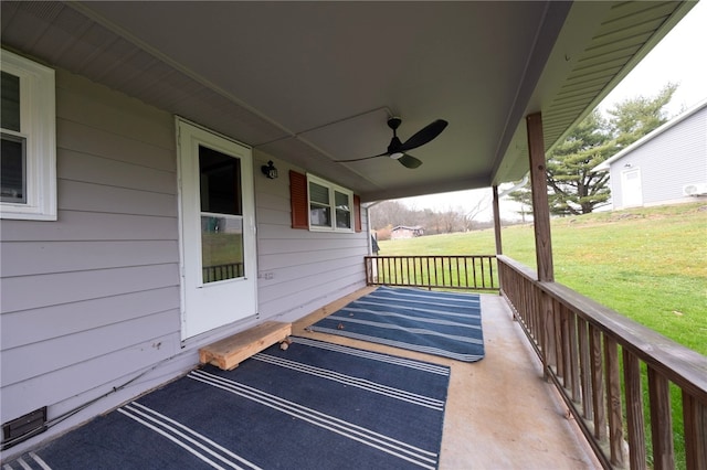 wooden deck with a lawn, ceiling fan, and covered porch