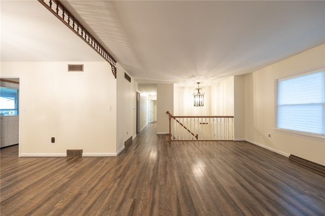 unfurnished room with dark hardwood / wood-style flooring and a chandelier