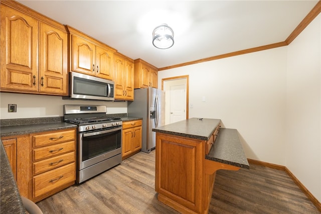 kitchen featuring wood-type flooring, ornamental molding, and stainless steel appliances