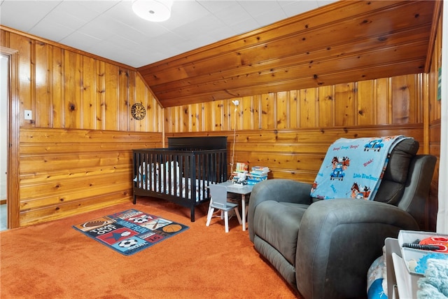 bedroom with carpet flooring, wooden walls, and vaulted ceiling