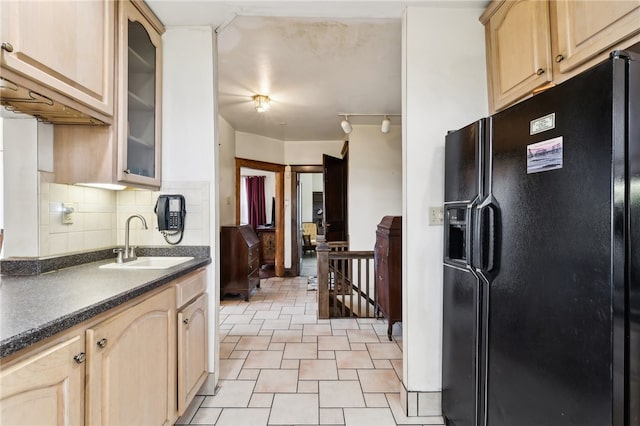 kitchen featuring light brown cabinetry, sink, black refrigerator with ice dispenser, and tasteful backsplash