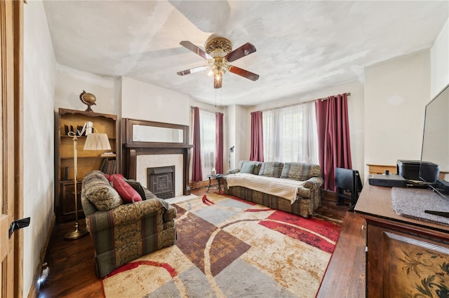 living room featuring a tile fireplace, dark hardwood / wood-style flooring, and ceiling fan