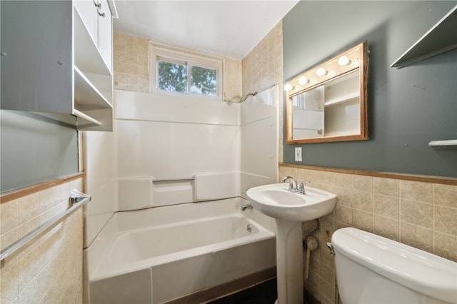 bathroom with shower / washtub combination, tile walls, and toilet