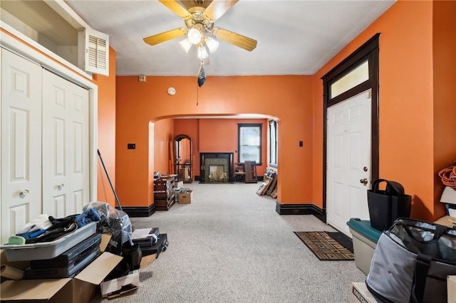 carpeted entryway with ceiling fan