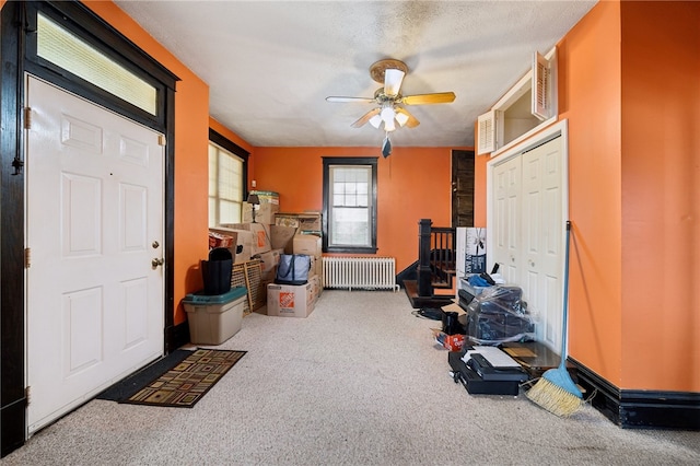 interior space featuring carpet flooring, radiator heating unit, a textured ceiling, and ceiling fan