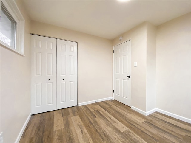 unfurnished bedroom with hardwood / wood-style floors and a closet