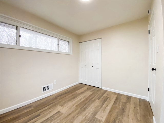 unfurnished bedroom featuring a closet and wood-type flooring