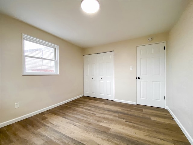 unfurnished bedroom featuring a closet and hardwood / wood-style flooring