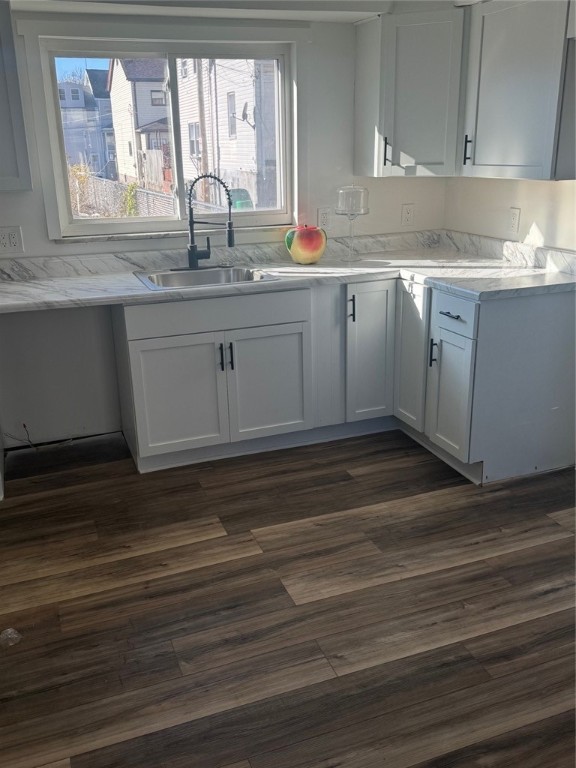 kitchen with dark hardwood / wood-style flooring, white cabinetry, and sink