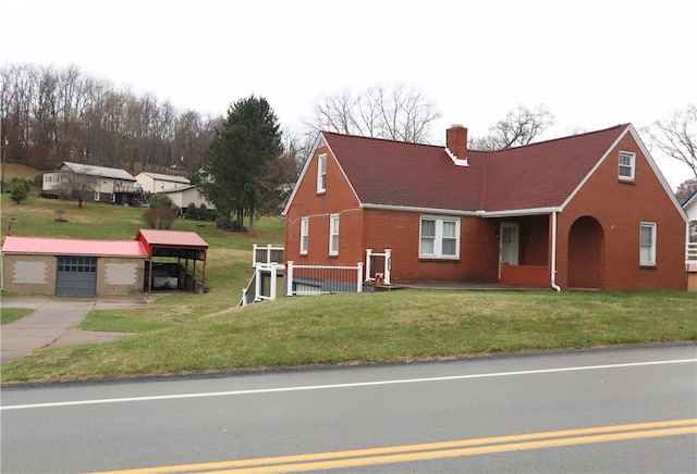 view of front facade with a front yard, an outdoor structure, and a garage