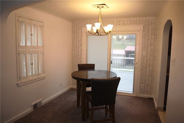 carpeted dining space featuring a notable chandelier