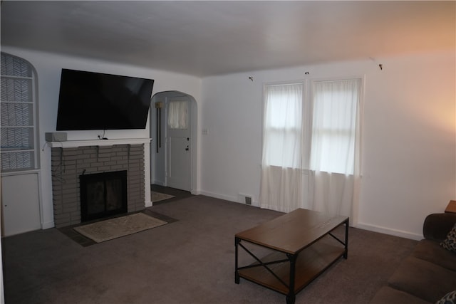 carpeted living room with a brick fireplace