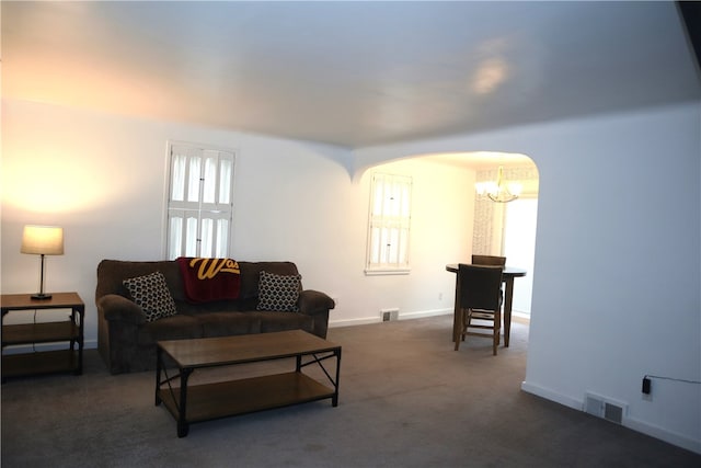 living room featuring dark colored carpet and a chandelier