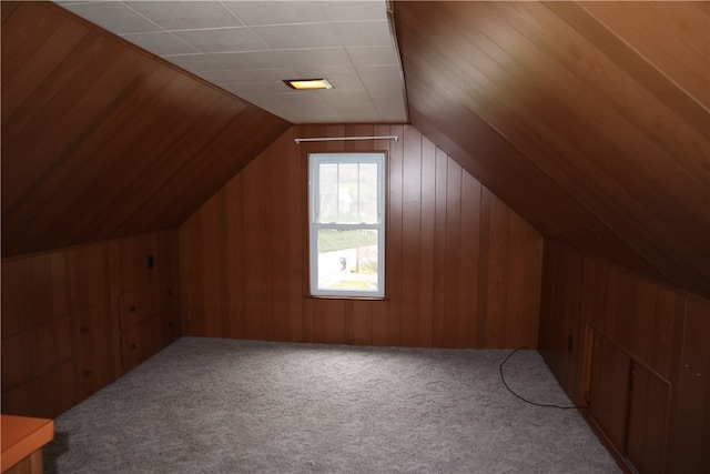 bonus room featuring carpet flooring, wood walls, and lofted ceiling