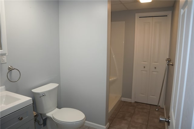 bathroom featuring tile patterned flooring, vanity, toilet, and walk in shower