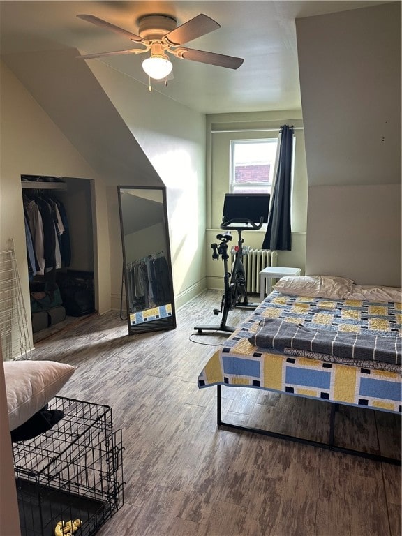 bedroom featuring wood-type flooring, a closet, ceiling fan, and radiator