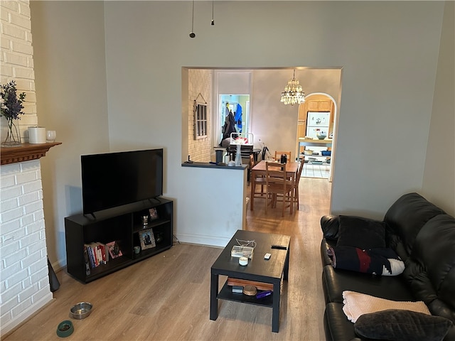 living room featuring wood-type flooring and an inviting chandelier