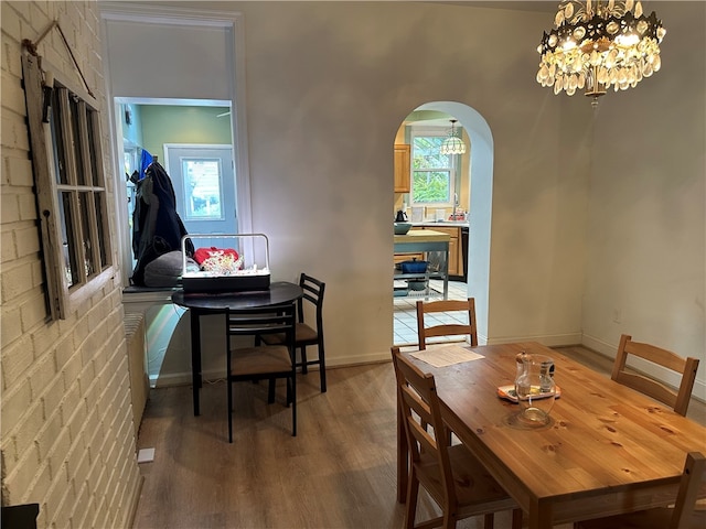 dining area featuring wood-type flooring and a notable chandelier