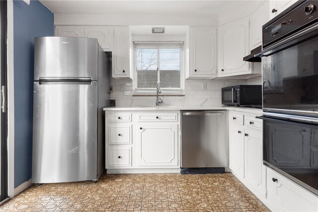 kitchen with a sink, white cabinets, light countertops, appliances with stainless steel finishes, and backsplash