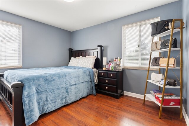 bedroom with baseboards and wood finished floors