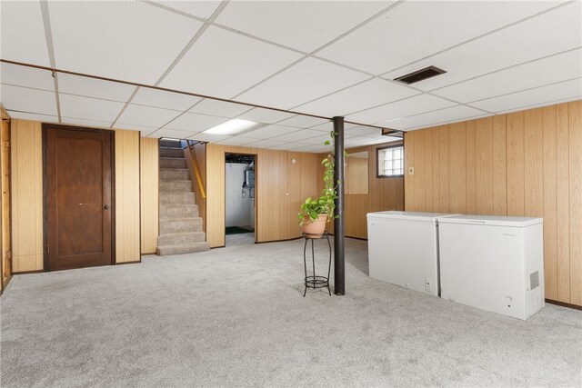 basement with carpet flooring, visible vents, stairs, fridge, and white fridge