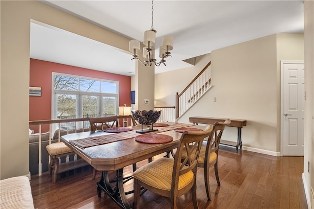 dining area featuring dark wood-type flooring and a chandelier