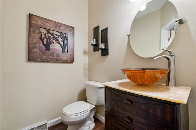 bathroom featuring vanity, hardwood / wood-style flooring, and toilet