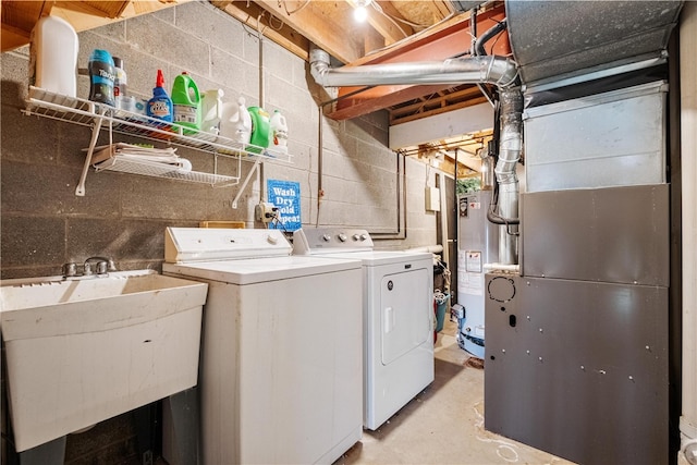 clothes washing area with gas water heater, independent washer and dryer, sink, and heating unit