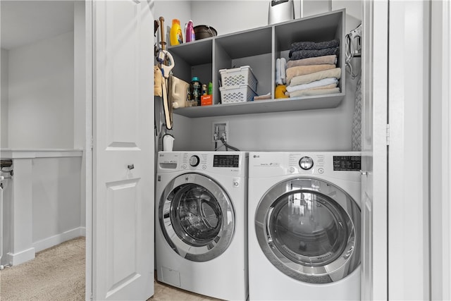 laundry area with washer and clothes dryer and light colored carpet