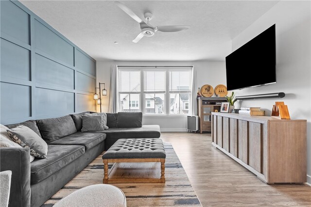 living room featuring light wood-type flooring and ceiling fan