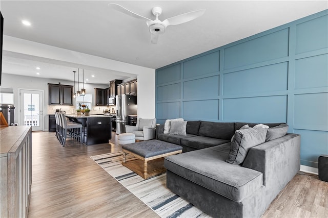 living room featuring light hardwood / wood-style floors and ceiling fan