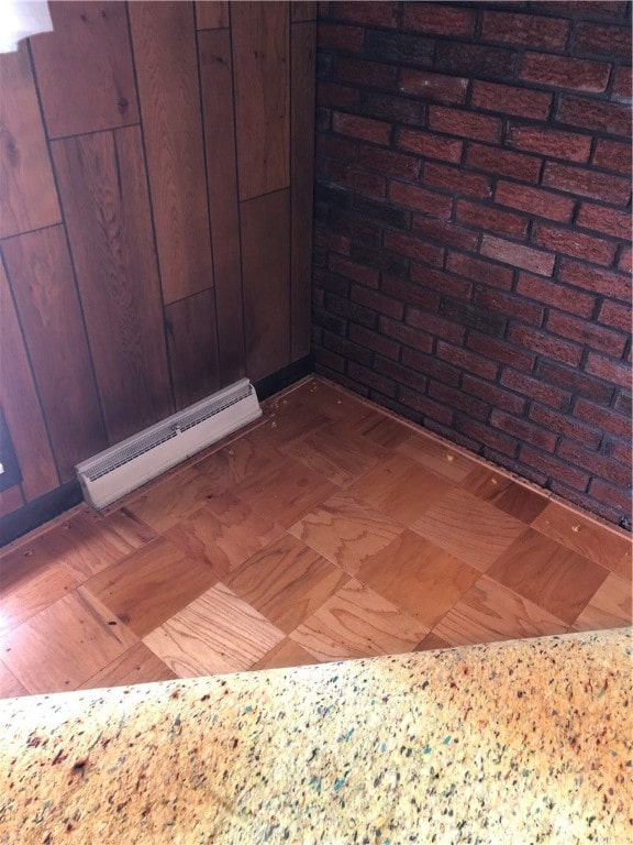 room details featuring wood walls and a baseboard heating unit