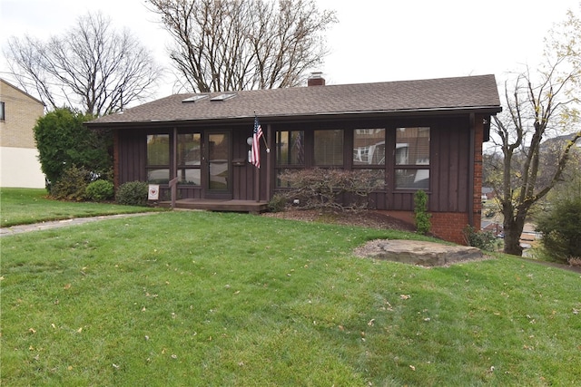 view of front facade with a sunroom and a front yard