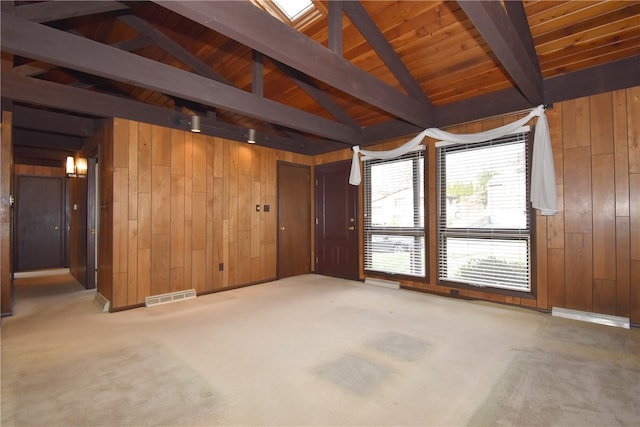 spare room featuring carpet, vaulted ceiling with beams, wood walls, and wood ceiling